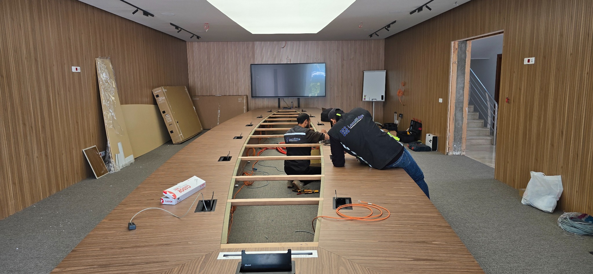 Techniciens LocalEdge intégrant les systèmes audiovisuels dans une table de salle de conseil