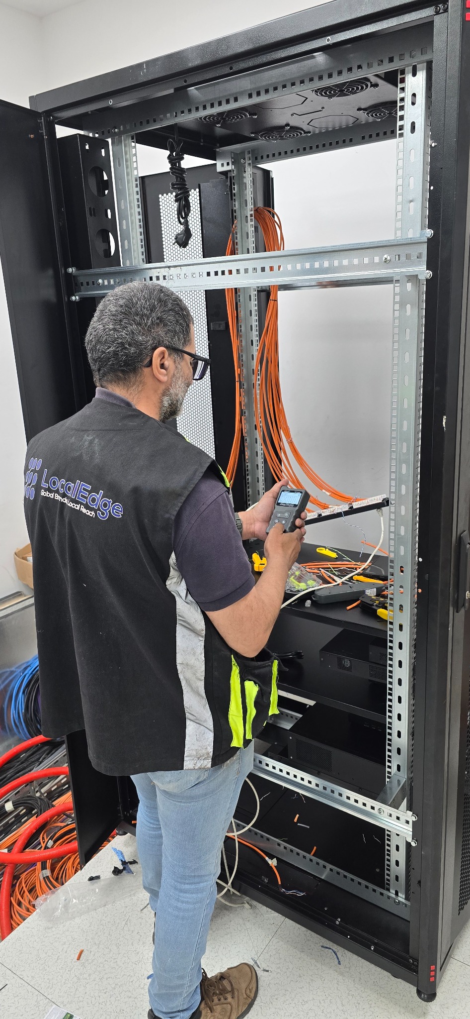 Technicien LocalEdge réalisant le câblage du rack audiovisuel